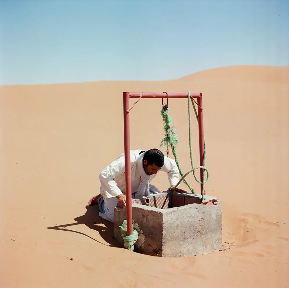 Mustapha looks down a well, from the series "Before it's gone" by M'hammed Kilito